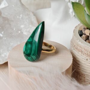 Élégante bague en malachite naturelle 31x15x6 mm. Monture ajustable en acier inoxydable doré. Pierre protectrice et apaisante, reconnue pour ses vertus anti-inflammatoires.